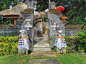 Split gates and figures of guardians at a small Balinese Hindu temple on the Bali Island in Indonesia photo