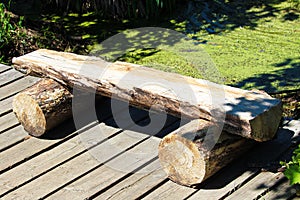 A split log wooden bench on a boardwalk trail