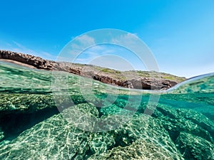 Split underwater view of Sardinia rocky shore