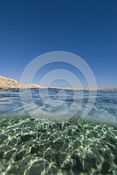 Split view desert coastline blue water