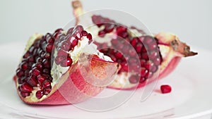 Splitted pomegranate fruit on plate rotates
