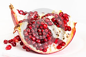 Splitted pomegranate fruit on plate on white