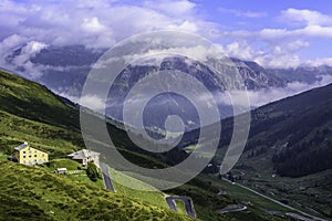 SPLÃÅGEN, SWITZERLAND - AUGUST 19, 2021: SplÃÂ¼gen pass road with mountain house SplÃÂ¼gen