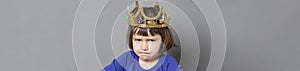 Preschooler with attitude sulking with mollycoddled kid crown, long banner