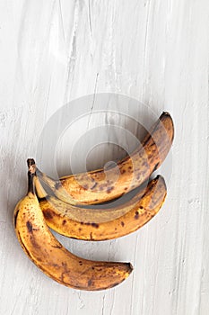 Spoiled tainted bananas on grey background. Ugly food trendy photo. Food waste, food garbage