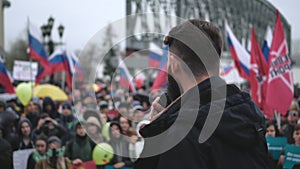 Spokesman on stage speaks via microphone with protesting strike crowd in Russia
