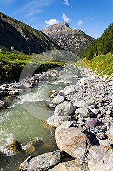 Spol River flowing in Lake Livigno, Corno Brusadella Mountain background photo