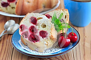 Sponge cake with cherries on the blue plate