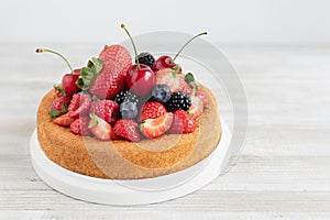 Sponge cake dessert with fresh sumer fruits on table