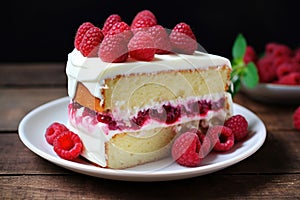 Sponge cake with fresh raspberries and cream on a white plate