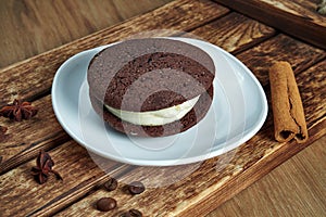Sponge cocoa cookies with white cream inside on a white plate. Tasty dessert for coffee. Food photo flat lay. Bakery. Whoopie pies