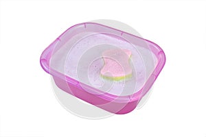 sponge floating on soap bubbles surface in purple pink square plastic basin