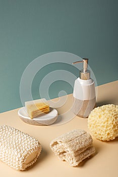 Sponges with liquid soap dispenser and soap dish on beige and grey, zero waste concept.