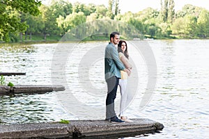 Spontaneous couple in love, embraced, on a stone pier.