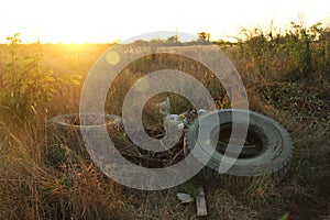 Spontaneous dump discarded tires and household rubbish . garbage dump on the side of a dirt road. The problem of recycling garbage