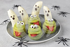 Spooky banana ghosts monsters and green kiwi monsters for Halloween party. Halloween Fruit Serving Idea