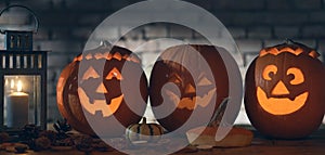 Spooky halloween carved pumpkin, jack o lantern on wooden table.