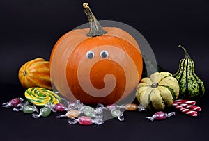 Spooky halloween pumpkin with eyes and candies stock images