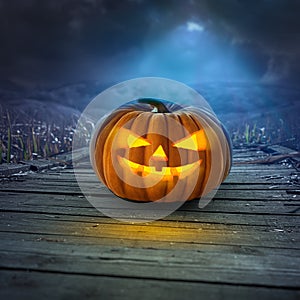 Spooky Halloween pumpkin on wooden path at night