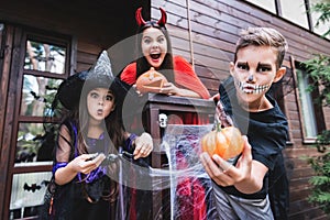 spooky kids in halloween costumes grimacing