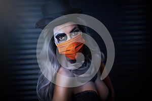 Spooky portrait of woman in halloween gotic makeup wearing protective mask