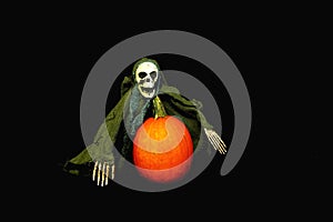 Spooky Skeleton on Halloween evening and pumpkin