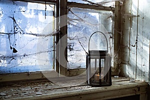 Spooky window with lantern and spider web