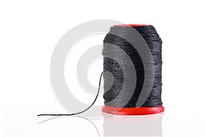Spool of black thread isolated with reflection