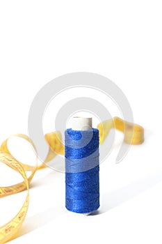 Spool of blue thread for sewing and centimeter on a white background. Copy space
