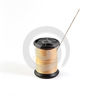 Spool of brown thread and needle