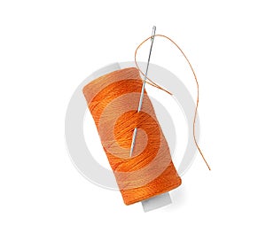 Spool of orange sewing thread with needle isolated on white, top view