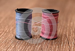 Spool of Pink and Blue Thread Intertwinning