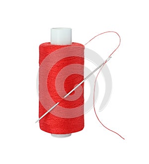 Spool of red sewing thread with needle isolated on white
