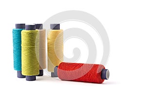Spool of sewing thread, different colors, on white background