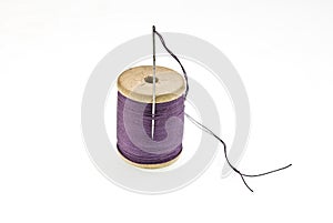 A spool of thread with a needle in it