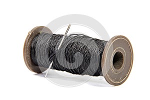 Spool of thread and needle isolated on white