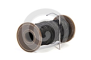 Spool of thread and needle isolated on white