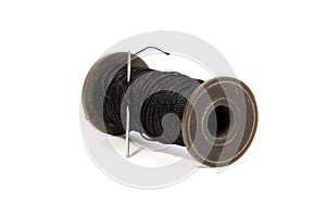 Spool of thread and needle isolated on white