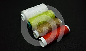 Spool threads isolated on the black background.