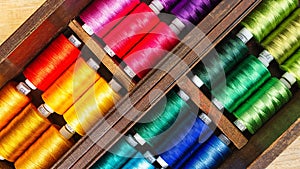 Spool of threads in the old wooden box, close up, top view picture