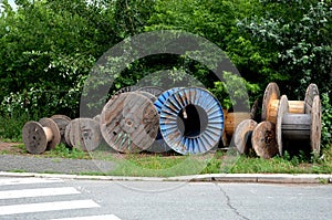 The spool is used for unloading cables, wires and pipes. warehouse of old wooden and metal spools by the road at a construction si
