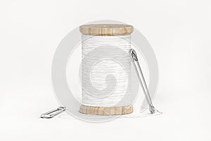 Spool of white thread and two safety pins