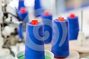 Spools of blue threads on sewing machine, factory