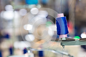 Spools of blue threads on sewing machine, factory