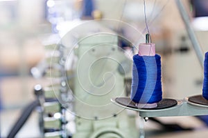 Spools of blue threads on sewing machine, factory