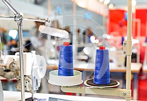Spools of blue threads on sewing machine, factory