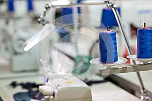 Spools of blue threads on sewing machine, factory