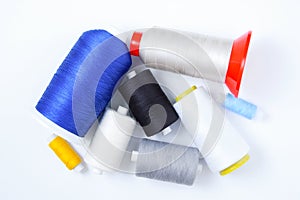 Spools and bobbins multi-colored sewing threads. White background