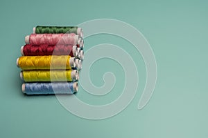 Spools of multi colored sewing thread stacked
