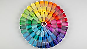 Spools of thread arranged in a circular pattern, creating a gradient effect